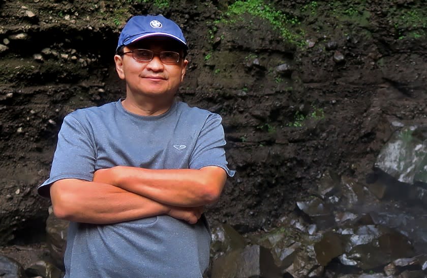 Harry Sentoso poses in front of a waterfall during a 2016 family trip back to his hometown of Malang, Indonesia.