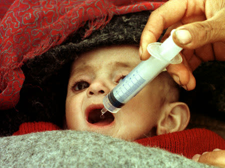 FILE PHOTO: An infant is fed glucose via a syringe in medical tent in Isikveren refugee camp, April 16, 1991. REUTERS/Yannis Behrakis/File photo