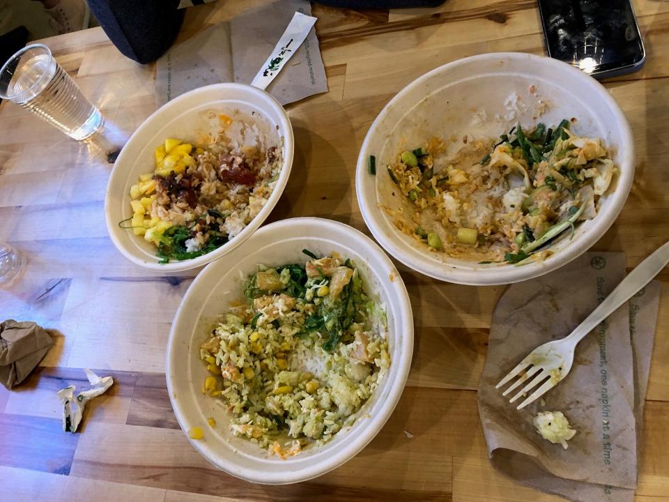 Three poke bowls on a wooden table at Poke Papa