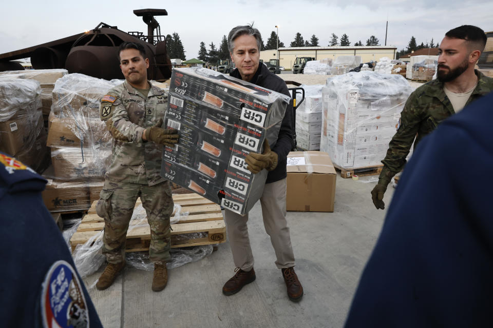 U.S. Secretary of State Antony Blinken helps U.S. military personnel carry aid, at Incirlik Air Base near Adana, Turkey, Sunday, Feb. 19, 2023. (Clodagh Kilcoyne/Pool Photo via AP)