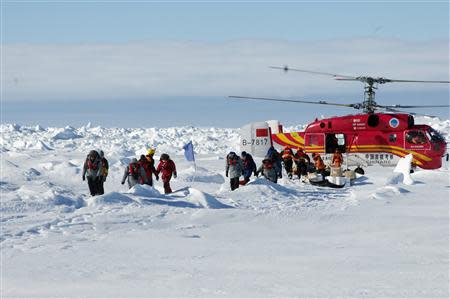 A helicopter from the Xue Long (Snow Dragon) Chinese icebreaker unloads rescued passengers from the ice-bound Russian ship, Akademik Shokalskiy, in East Antarctica, some 100 nautical miles (185 km) east of French Antarctic station Dumont D'Urville and about 1,500 nautical miles (2,800 km) south of Hobart, Tasmania, January 2, 2014, in this handout courtesy of Fairfax's Australian Antarctic Division. REUTERS/Fairfax/Australian Antarctic Division/Handout via Reuters