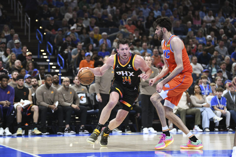 Phoenix Suns forward Drew Eubanks, left, drives past Oklahoma City Thunder forward Chet Holmgren during the first half of an NBA basketball game Friday, March 29, 2024, in Oklahoma City. (AP Photo/Kyle Phillips)