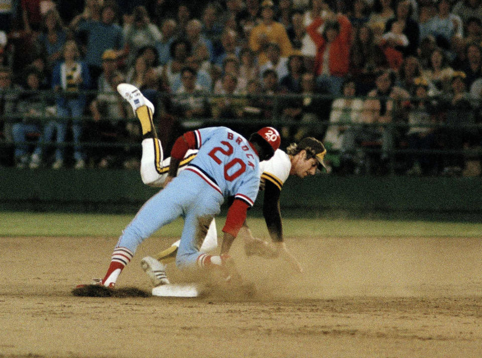 FILE - In this Aug. 30, 1977, file photo, St. Louis Cardinals' Lou Brock (20) lands on his feet after stealing second base in the seventh inning against the San Diego Padres, breaking Ty Cobb's major league record of 892 stolen bases, in San Diego, Calif. Padres shortstop Bill Almon falls after missing the throw. Hall of Famer Brock, one of baseball’s signature leadoff hitters and base stealers who helped the Cardinals win three pennants and two World Series titles in the 1960s, has died. He was 81. (AP Photo, File)