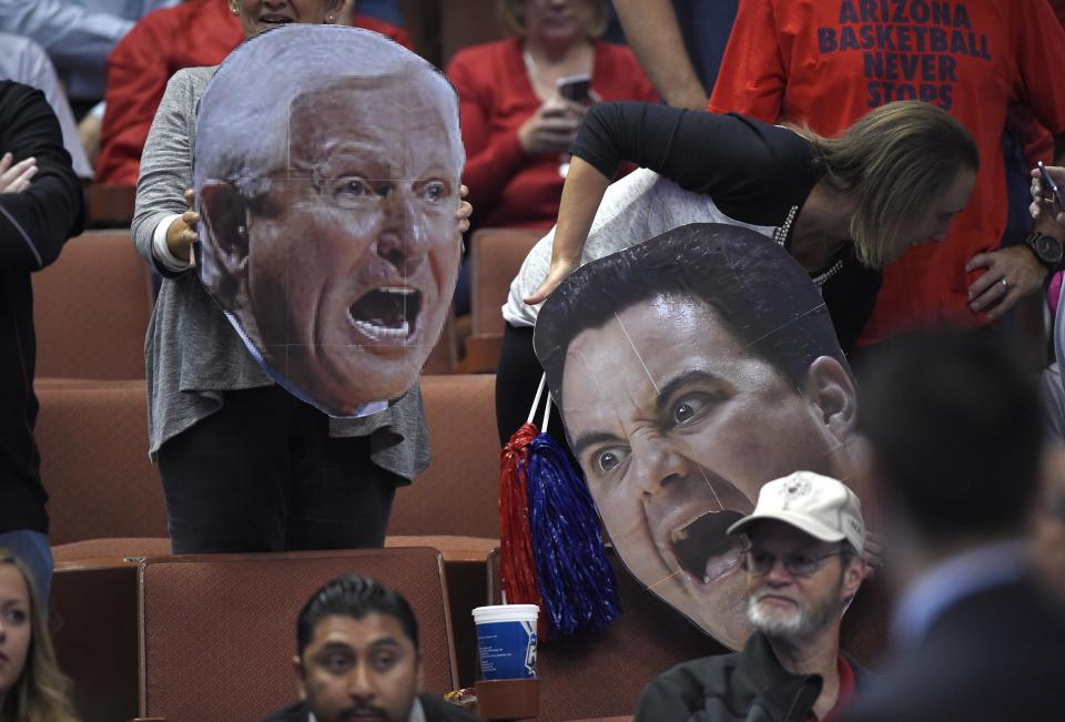 Arizona fans hold a cut out of former coach Lute Olsen, left, and San Diego State fans hold a cut out of head coach Sean Miller prior to a regional semifinal NCAA college basketball tournament game, Thursday, March 27, 2014, in Anaheim, Calif. (AP Photo/Mark J. Terrill)