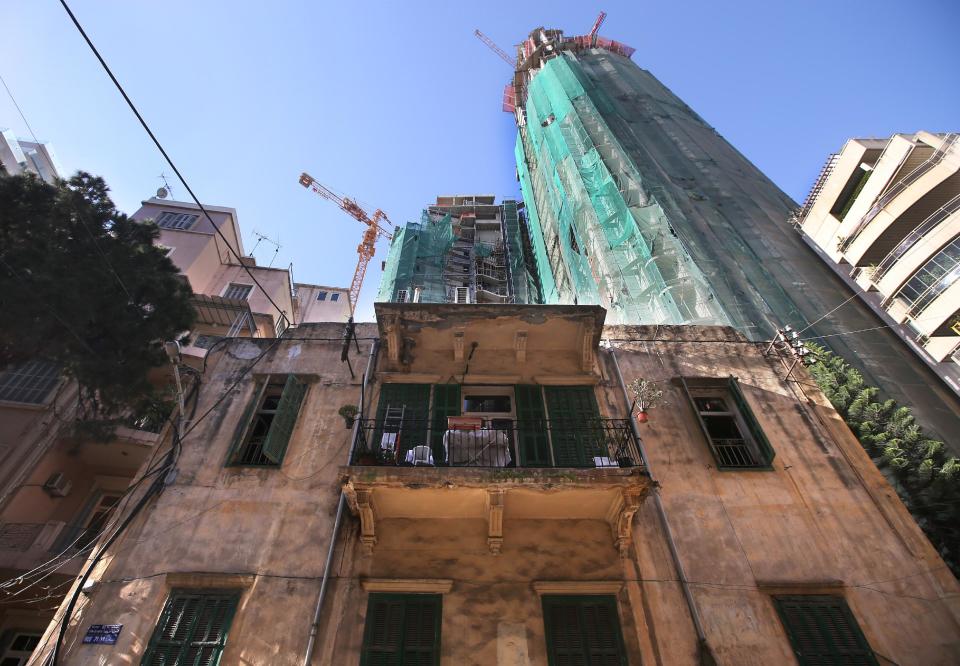 In this April 9, 2014 photo, an old house is overshadowed by newer, taller modern buildings, some still under construction, in Beirut, Lebanon. Beirut is no different than Dubai, Doha or other major world cities overtaken by a global trend for modern, tall buildings. But in a country that prides itself on its rich history, many complain that Lebanon is losing its charm and character, often said to be the only thing going for it. (AP Photo/Hussein Malla)