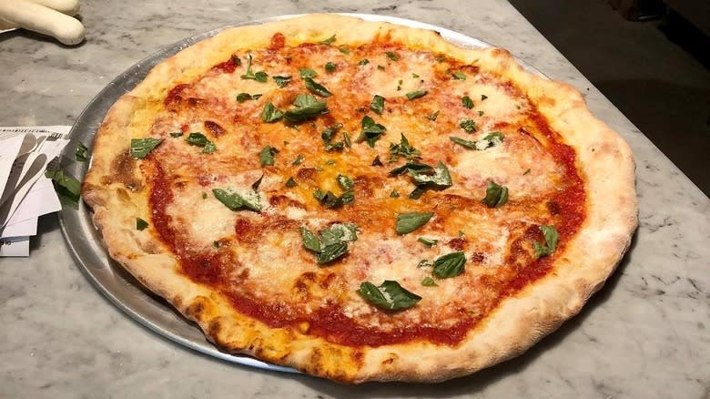 unsliced cheese pizza with basil