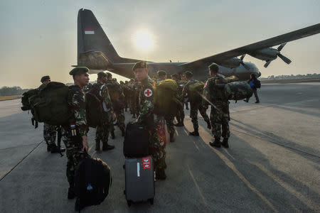 Indonesian soldiers walk to a Hercules military plane heading to Palu at Halim Perdanakusuma military base in Jakarta, Indonesia, September 29, 2018. Antara Foto/Muhammad Adimaja via REUTERS