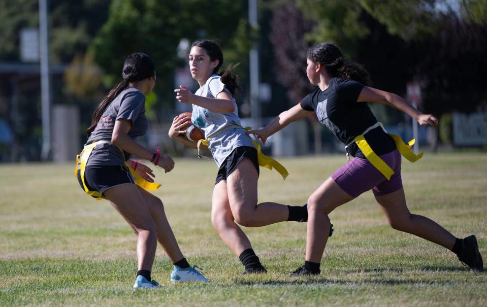 Andrea Fuentes, middle, runs the ball during Escalon girls flag football practice at Escalon High School in Escalon, Calif., Thursday, August 3, 2023.