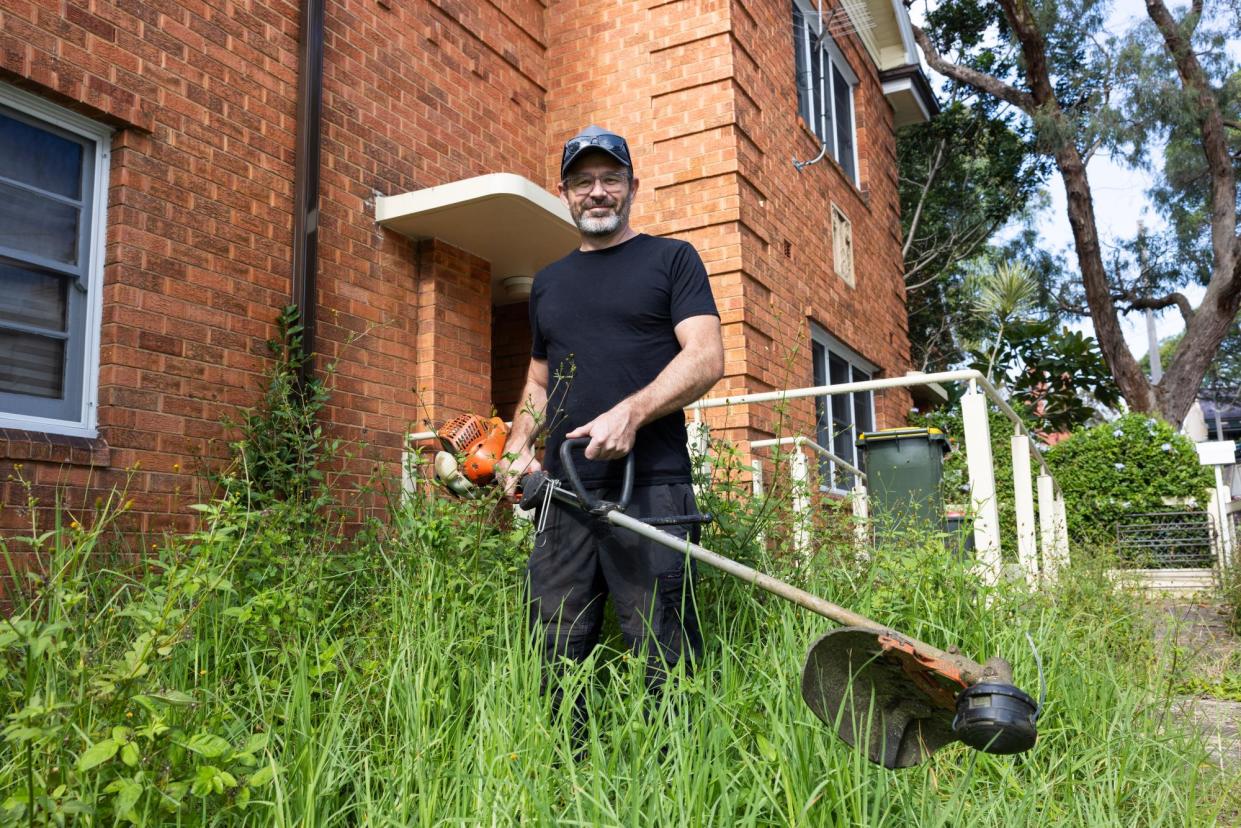 <span>Nathan Stafford trims the lawn of a home in a social housing block for free in Glebe, central Sydney.</span><span>Photograph: Blake Sharp-Wiggins/The Guardian</span>