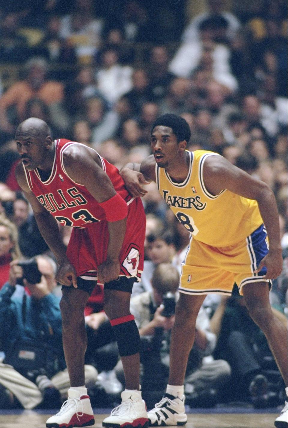 Michael Jordan and a young Kobe Bryant during a Bulls-Lakers game in the 1997-98 season. (Getty Images)