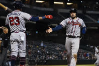 Atlanta Braves' Travis d'Arnaud greets Ehire Adrianza (23) as he scores on a base hit by Dansby Swanson during the ninth inning of a baseball game against the Arizona Diamondbacks, Tuesday, Sept. 21, 2021, in Phoenix. (AP Photo/Matt York)