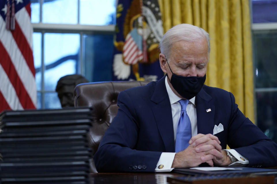 President Joe Biden pauses as he signs his first executive orders in the Oval Office of the White House on Wednesday, Jan. 20, 2021, in Washington. (AP Photo/Evan Vucci)