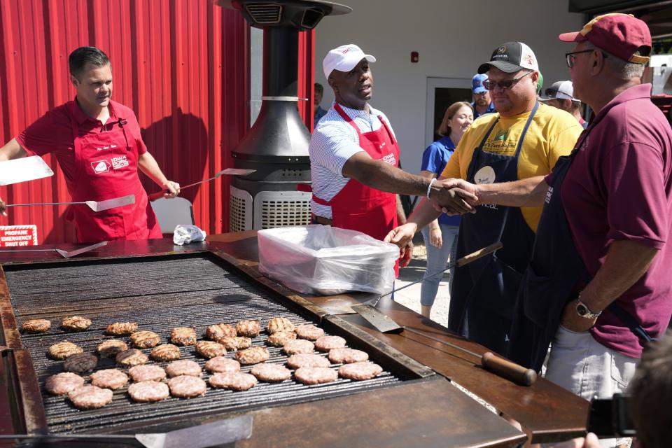 Sen. Tim Scott greets workers before working the grill at the Iowa Pork Producers tent at the Iowa State Fair in Des Moines, Iowa.