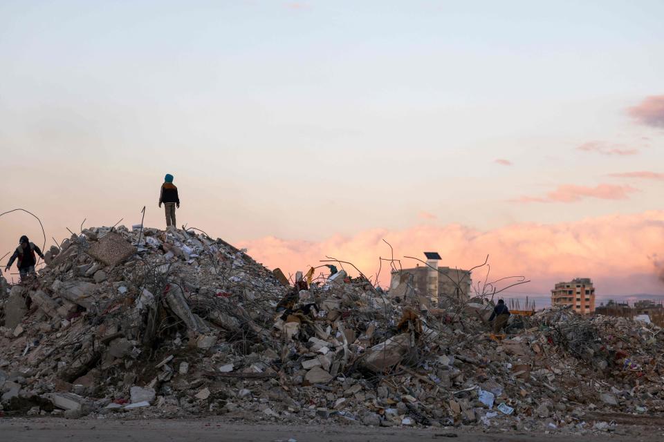 Syrians search earthquake rubble for items to salvage on Feb. 10, 2023, northwest of the capital, Damascus.