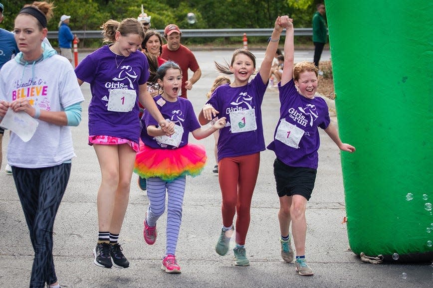 Girls on the Run 5K Season participants celebrate crossing the finish line at the Spring 2023 AdventHealth GOTR 5K