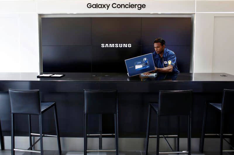 A worker cleans a Samsung showroom in New Delhi