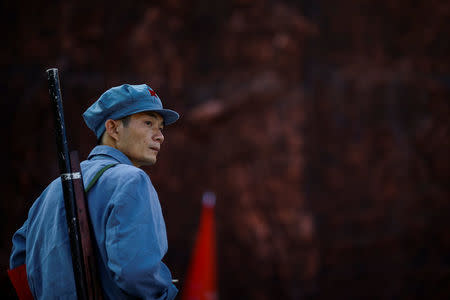 A participant wears a replica red army uniform and carries a mock-up rifle during a Communist team-building course extolling the spirit of the Long March in the mountains outside Jinggangshan, Jiangxi province, China, September 14, 2017. REUTERS/Thomas Peter