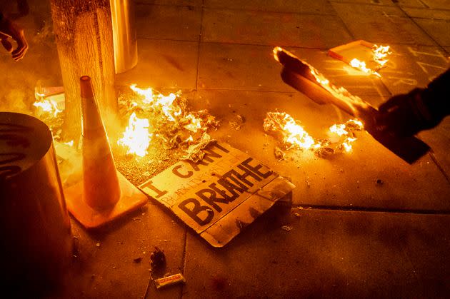 A Black Lives Matter protester burns a sign outside the Mark O. Hatfield U.S. Courthouse on July 21, 2020, in Portland, Oregon. Protests spread across the country after the police killing of George Floyd in Minneapolis on May 25, 2020.