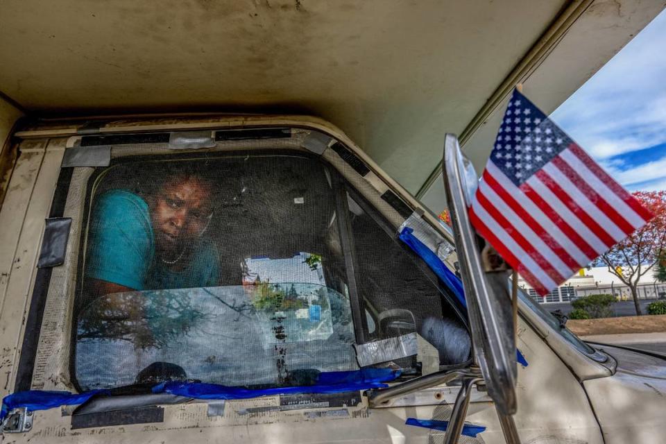 Rosita Howard, 45, speaks through the window of her RV, parked on Winona Way in North Highlands near a planned “Safe Stay” housing site, in November. She said the Sheriff’s department had come by earlier to tell her and her husband they had to move, but offered them no suggestions about where to go. “No reason why they came and no offer for resources,” Howard said.