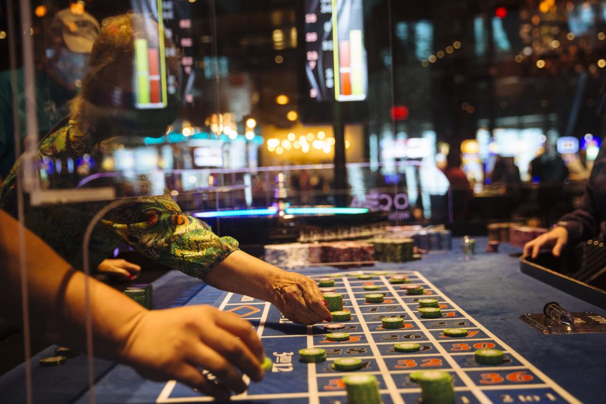 Visitors reach under a plastic shield to place their bets at a roulette table at Ocean Casino Resort in Atlantic City, New Jersey, U.S., on Thursday, July 2, 2020. Photographer: Angus Mordant/Bloomberg