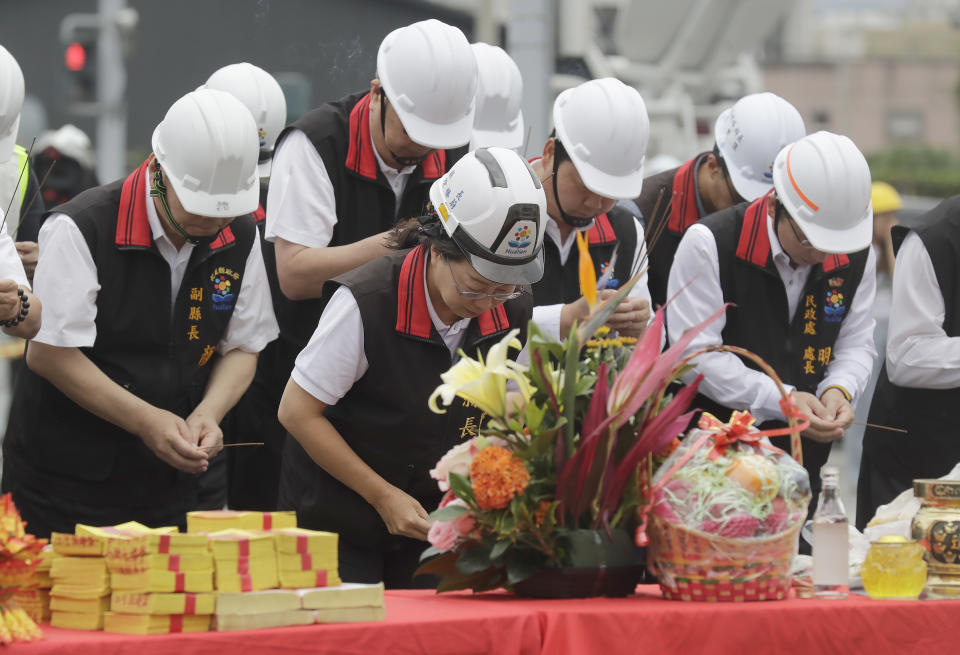 Huilien County magistrate Hsu Chen-wei, second from left, with government officials, offer prayers during the demolition ceremony for the partially collapsed building, two days after a powerful earthquake struck the city, in Hualien City, eastern Taiwan, Friday, April 5, 2024. Rescuers searched Thursday for missing people and worked to reach hundreds stranded when Taiwan's strongest earthquake in 25 years sent boulders and mud tumbling down mountainsides, blocking roads. (AP Photo/Chiang Ying-ying)