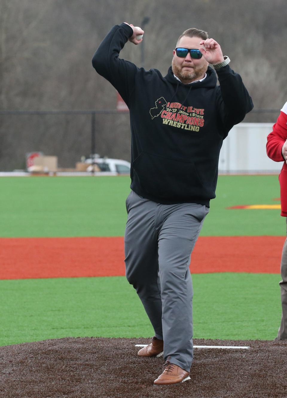 Mt. Olive School Superintendent Robert Zywicki throws out the first pitch as Mt. Olive High School unveiled and played their first game at their new baseball complex against West Morris on April 27, 2022.