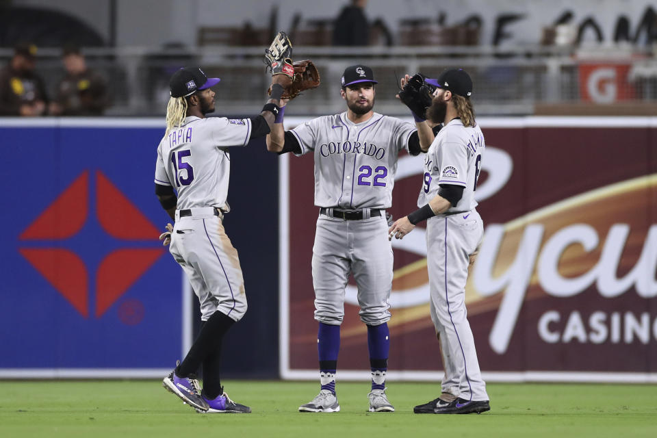 Colorado Rockies outfielders Raimel Tapia, left, Sam Hilliard (22) and Charlie Blackmon celebrate after the Rockies defeated the San Diego Padres in a baseball game Friday, July 30, 2021, in San Diego. (AP Photo/Derrick Tuskan)