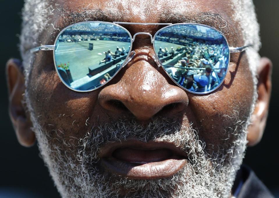 FILE - In this April 7, 2012, file photo, Richard Williams cheers for his daughter, Serena Williams, between points of her semifinal match against Samantha Stosur, of Australia, at the Family Circle Cup tennis tournament in Charleston, S.C. His new book, "Black and White: The Way I See It," comes out May 6. It goes into detail about how Indian Wells, as he writes, "disgraced America." (AP Photo/Mic Smith, File)