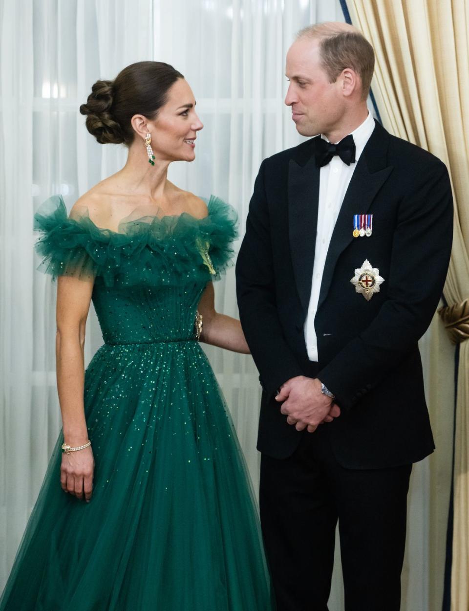 <p>The Duchess of Cambridge put her arm around her husband during a dinner hosted by the Governor General of Jamaica at King's House in March 2022. The pair were seen looking lovingly into each other's eyes all evening. </p>