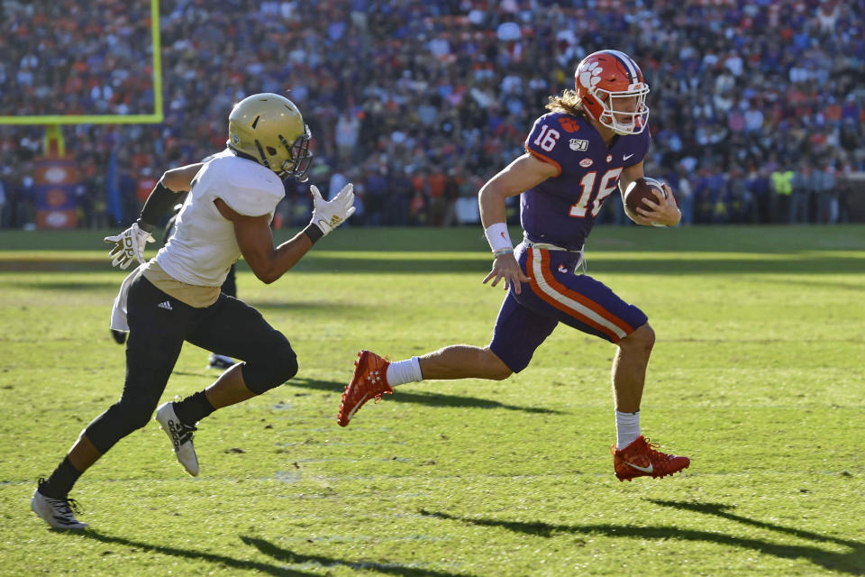 Clemson quarterback Trevor Lawrence (16) runs on a quarterback-keeper for a touchdown while defended by Wofford's Keyvaun Cobb during the first half of an NCAA college football game, Saturday, Nov. 2, 2019, in Clemson, S.C. (AP Photo/Richard Shiro)
