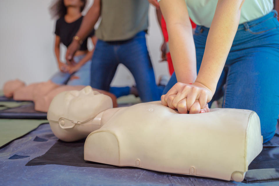 young person performing CPR on a test dummy