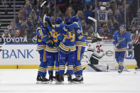 St. Louis Blues' Mike Hoffman (68) is congratulated by teammates after scoring the tying goal against the Minnesota Wild during the third period of an NHL hockey game on Saturday, April 10, 2021, in St. Louis. (AP Photo/Joe Puetz)