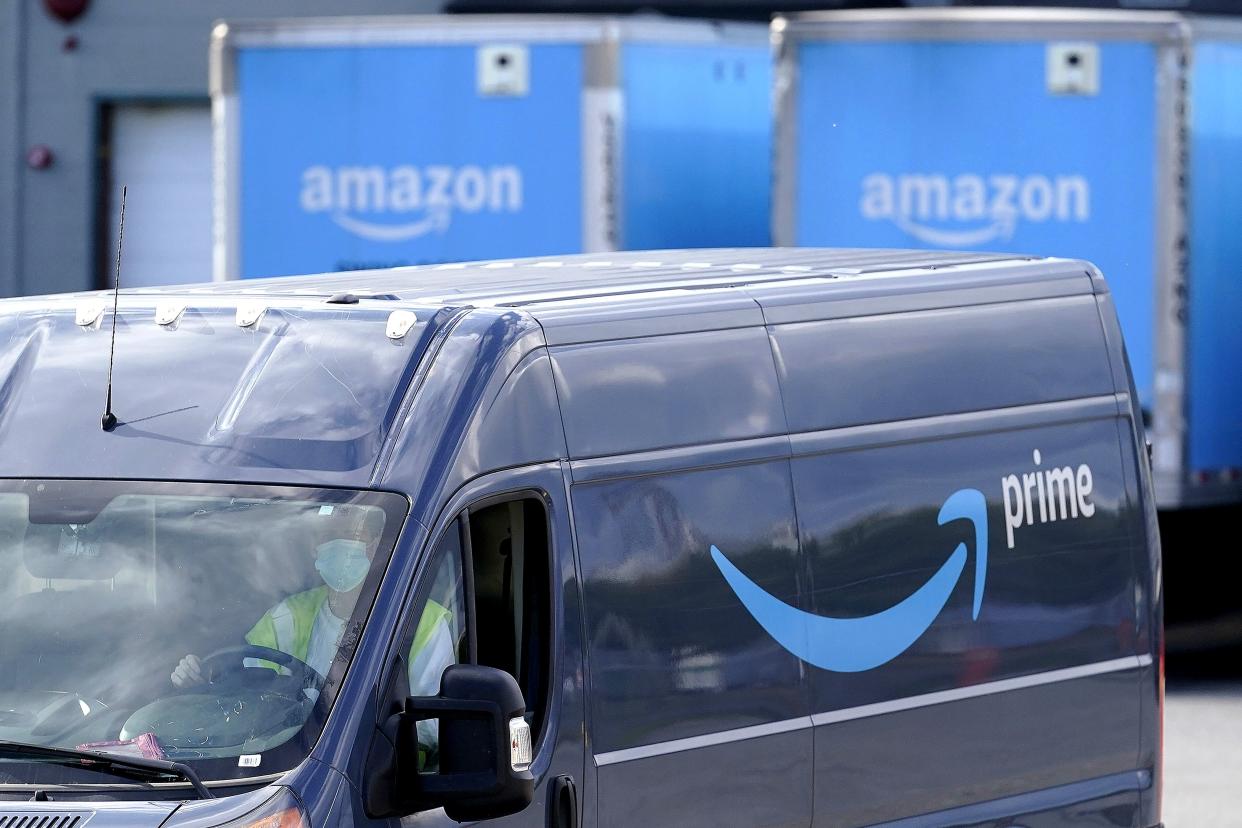 An Amazon Prime logo appears on the side of a delivery van as it departs an Amazon Warehouse location in Dedham, Mass., Oct. 1, 2020. 