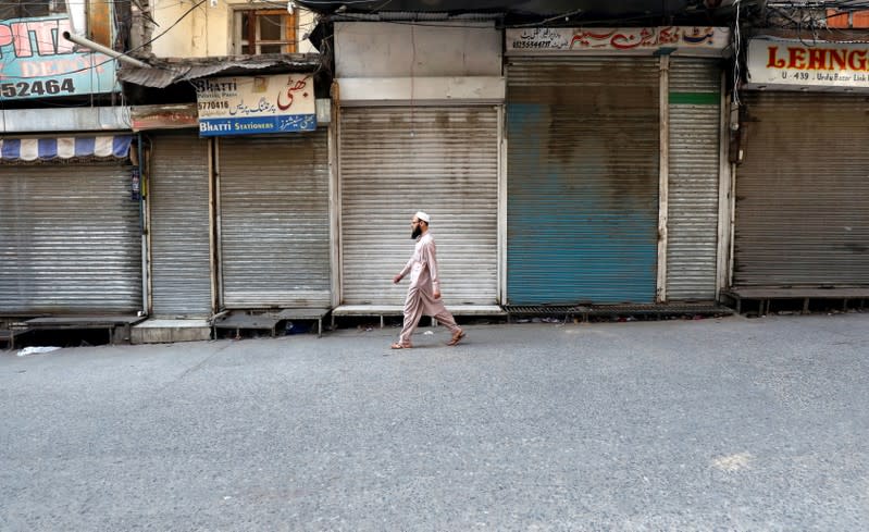 A man walks past closed shops during a country-wide lock down by the traders and business community against, what they say is imposition of taxes by the government in Rawalpindi