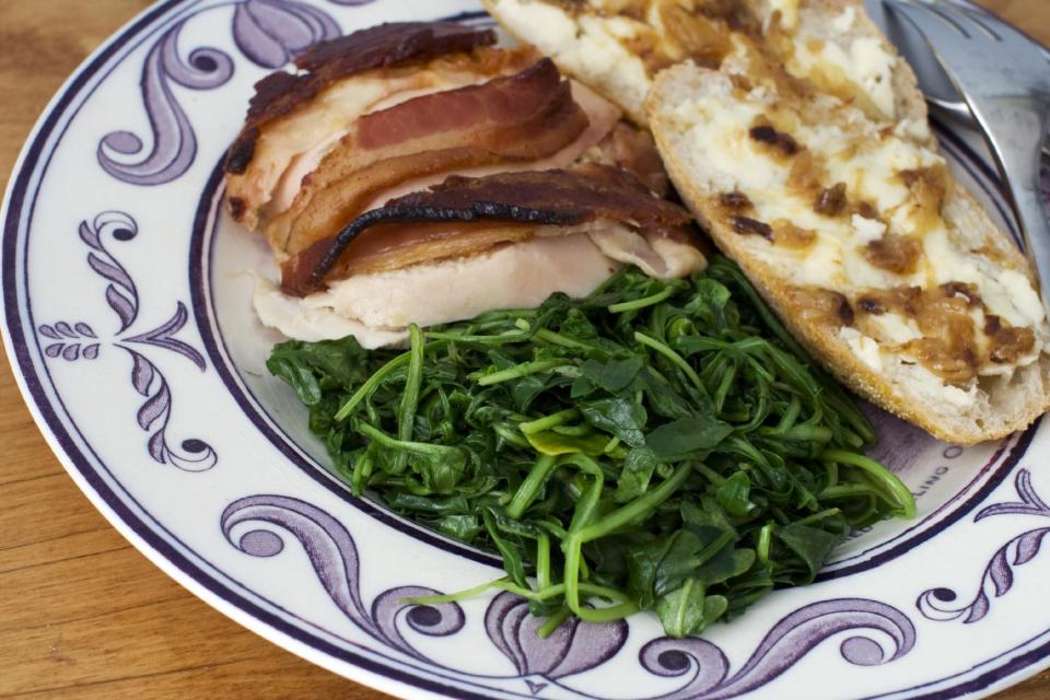 In this image taken on February 11, 2013, roasted chicken with 40 cloves of garlic and a bacon blanket is shown in Concord, N.H. (AP Photo/Matthew Mead)