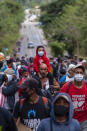 A Honduran migrant carrying a child on his shoulders walks with other migrants alongside a highway in Chiquimula, Guatemala, Saturday, Jan. 16, 2021, in hopes of reaching the U.S. border. Guatemalan authorities estimated that as many as 9,000 Honduran migrants have crossed into Guatemala as part of an effort to form a new caravan to reach the U.S. border. (AP Photo/Sandra Sebastian)