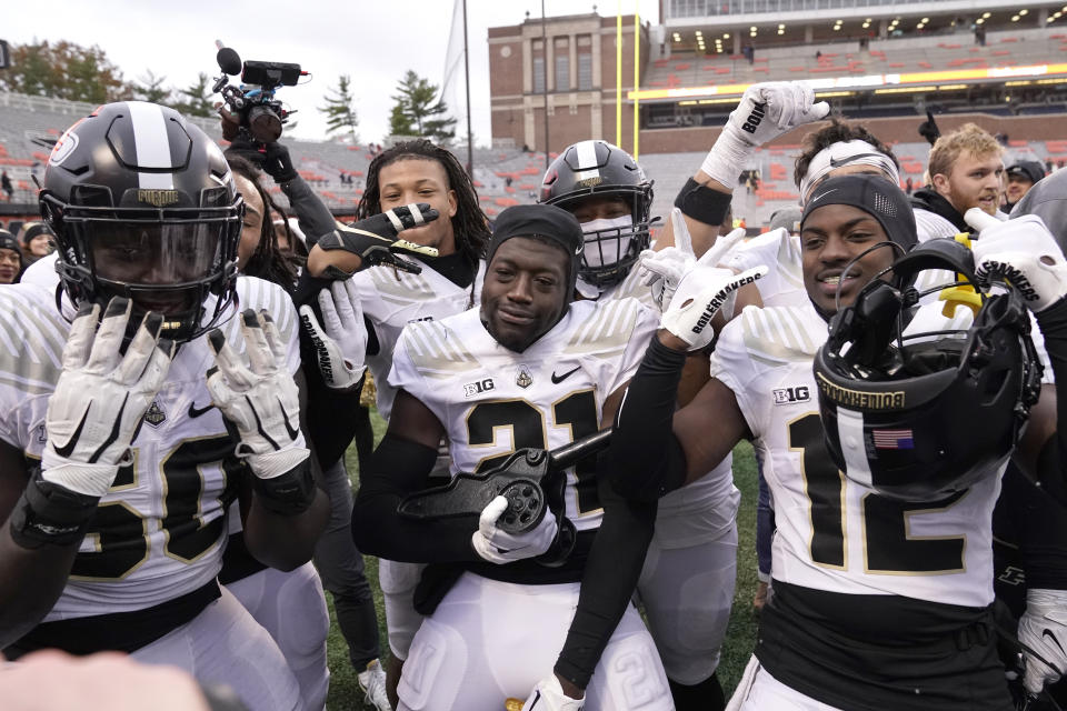 Purdue players poses with the Purdue Canon after retaining it in their rivalry with Illinois with a 31-24 win after an NCAA college football game Saturday, Nov. 12, 2022, in Champaign, Ill. (AP Photo/Charles Rex Arbogast)