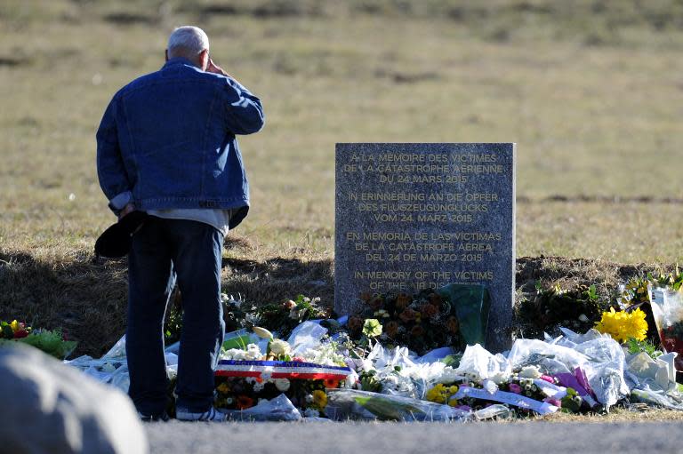 A man stands in front of a commemorative headstone in Seyne-les-Alpes, the closest accessible site to where a Germanwings Airbus A320 crashed on March 24 in the French Alps, killing all 150 people on board