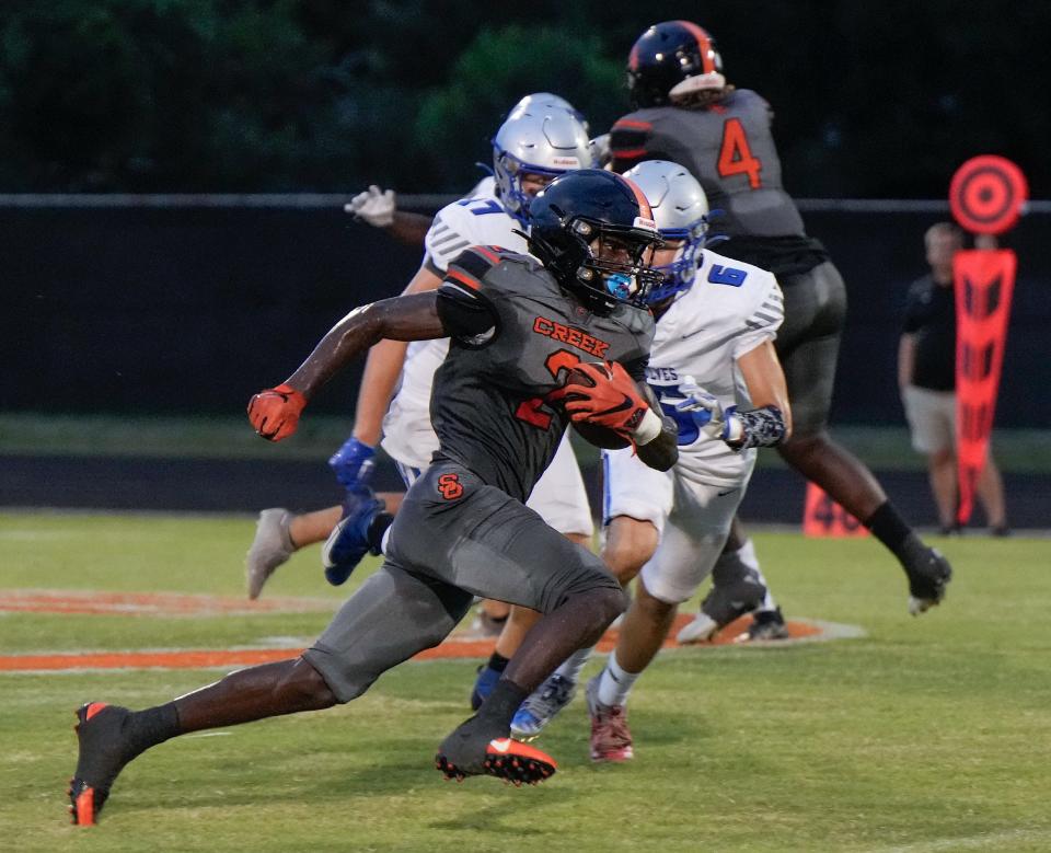 Spruce Creek's Tony Kinsler (2) attempts to elude Deltona's Angel Santiago during a game at Spruce Creek High School in Port Orange, Friday, Sept. 1, 2023. 