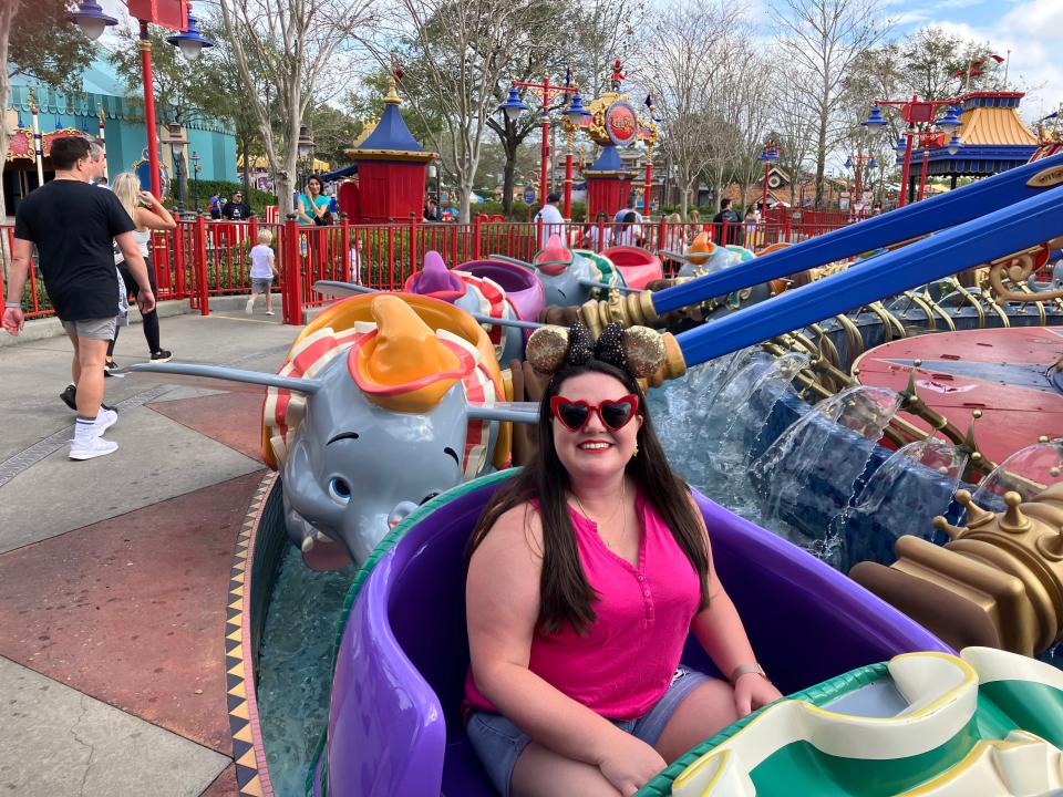 megan riding dumbo the flying elephant at disney world as an adult
