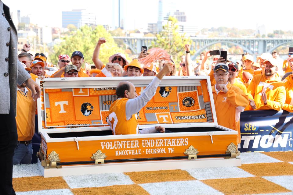 Paul Finebaum of "SEC Nation" springs from a Tennessee casket on Saturday, Oct. 15, 2022, as he predicts the Vols will beat Alabama. The owner of the casket, Horace Perkins III, stands at the right side of the casket.