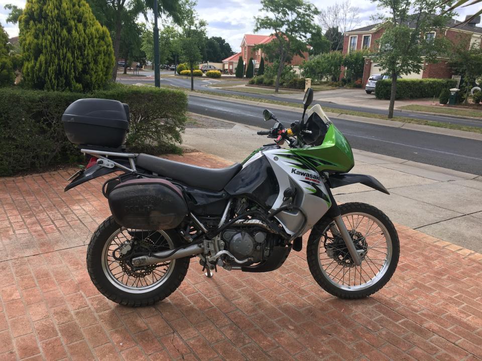Pictured is a Kawasaki motorbike on a driveway.