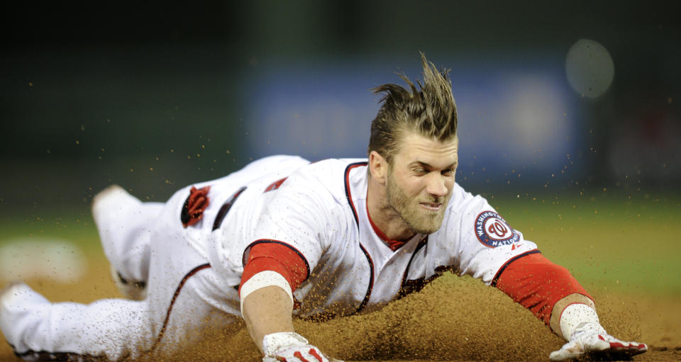 Washington Nationals left fielder Bryce Harper slides into third with a three RBI triple during the third inning of a baseball game against the San Diego Padres, Friday, April 25, 2014, in Washington. (AP Photo/Nick Wass)