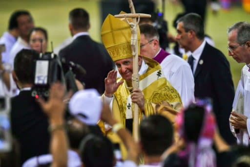 Pope Francis arrived at the stadium in a golden robe woven for him from Thai silk