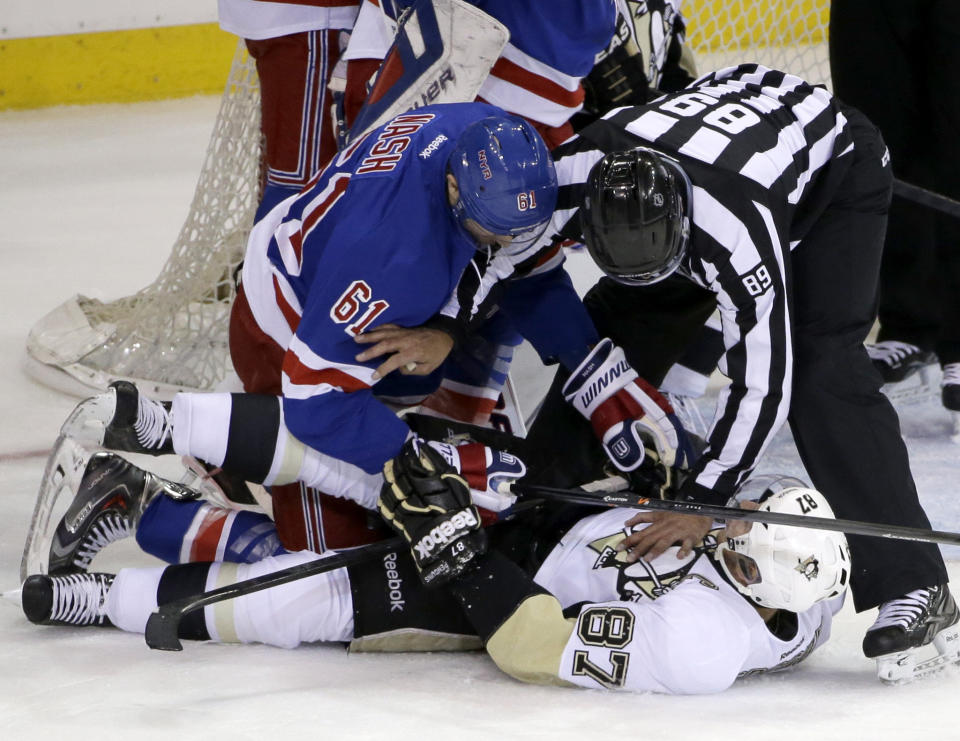 A referee (89) separates New York Rangers left wing Rick Nash (61) and Pittsburgh Penguins center Sidney Crosby (87) during the first period of Game 6 of a second-round NHL playoff hockey series on Sunday, May 11, 2014, in New York. (AP Photo/Seth Wenig)