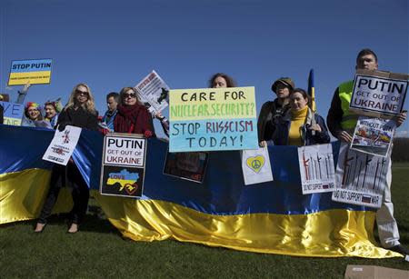 People hold posters and banners at an international protest during the Nuclear Security Summit at Malieveld in The Hague March 24, 2014. REUTERS/Cris Toala Olivares