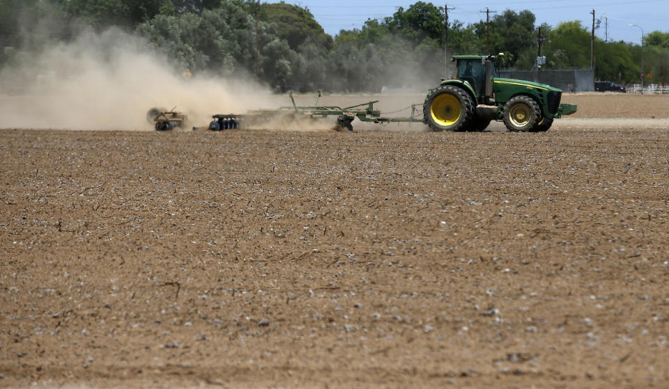 FILE - In this May 23, 2018 file photo a farmer plows a dry and dusty cotton field in Phoenix. Arizona farmers will soon begin planting commercial hemp under a 2018 state law that just took effect once the state issues required licenses. (AP Photo/Ross D. Franklin,File)