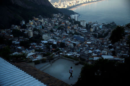 A guest walks along a terrace at Alto Vidigal hostel in Vidigal favela, in Rio de Janeiro, Brazil, April 23, 2016. REUTERS/Pilar Olivares