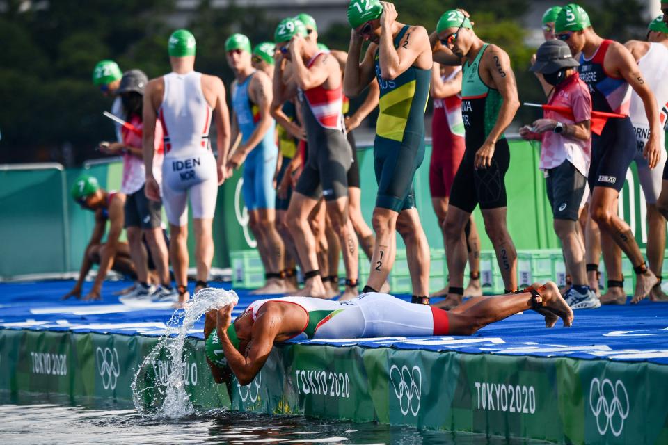 <p>Athletes prepare to compete in the men's individual triathlon competition during the Tokyo 2020 Olympic Games at the Odaiba Marine Park in Tokyo on July 26, 2021. (Photo by Loic VENANCE / AFP)</p> 