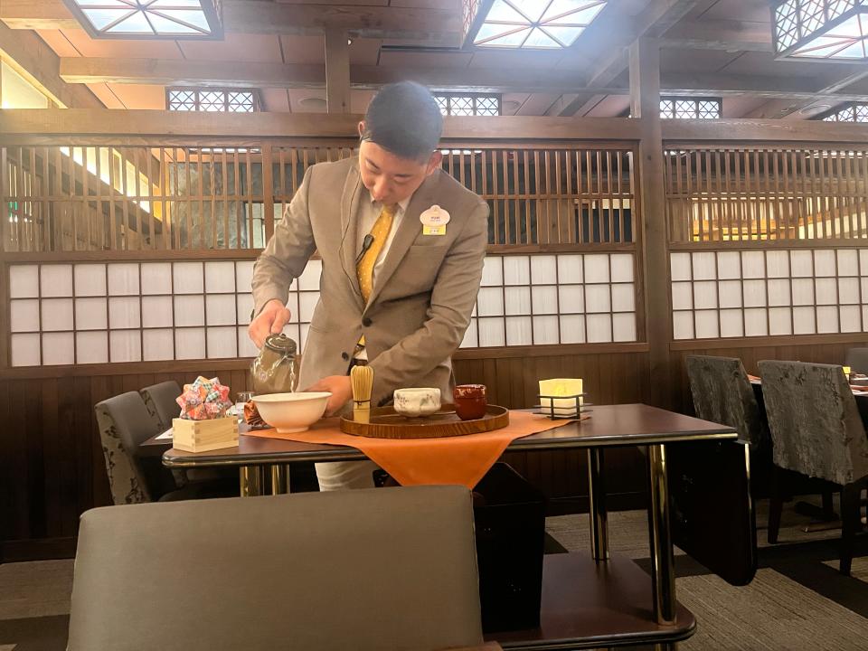 employee making tea for casey at Takumi-Tei restaurant in epcot at disney world